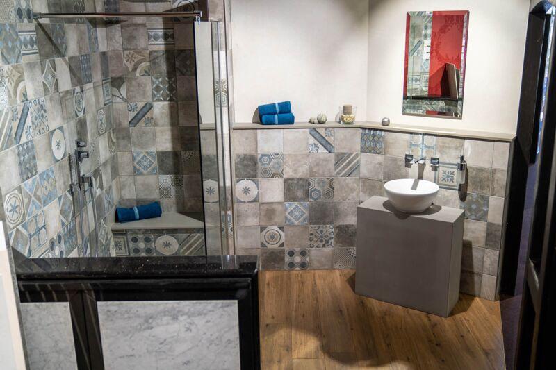 Badkoje mit grau-blauen Patchwork-Fliesen, Walk-in-Dusche und Boden in Holzoptik